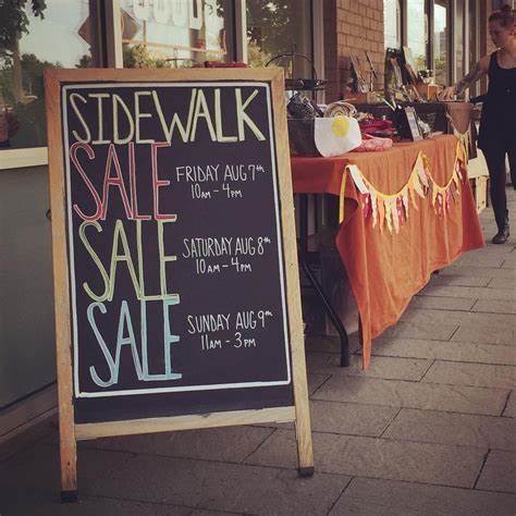 Sidewalk sale chalkboard sign outside a local store